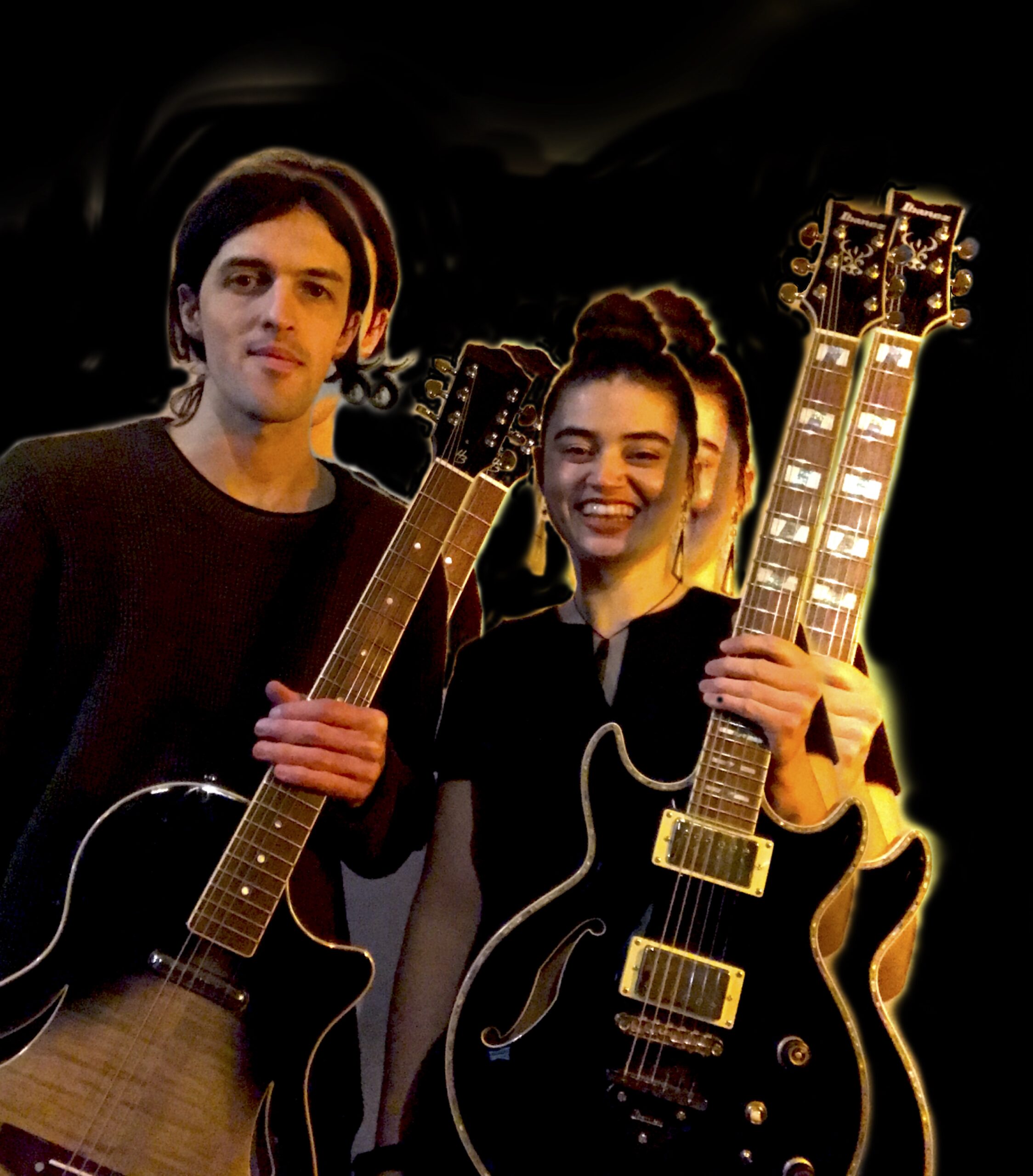 Zwei Musiker mit Elektrogitarren vor dunklem Hintergrund, plötzliches Doppelbild durch Lichtspuren, der Mann links hält eine Gitarre mit hellem Holzkorpus, die Frau rechts lächelt und hält eine schwarze Doppelhalsgitarre.