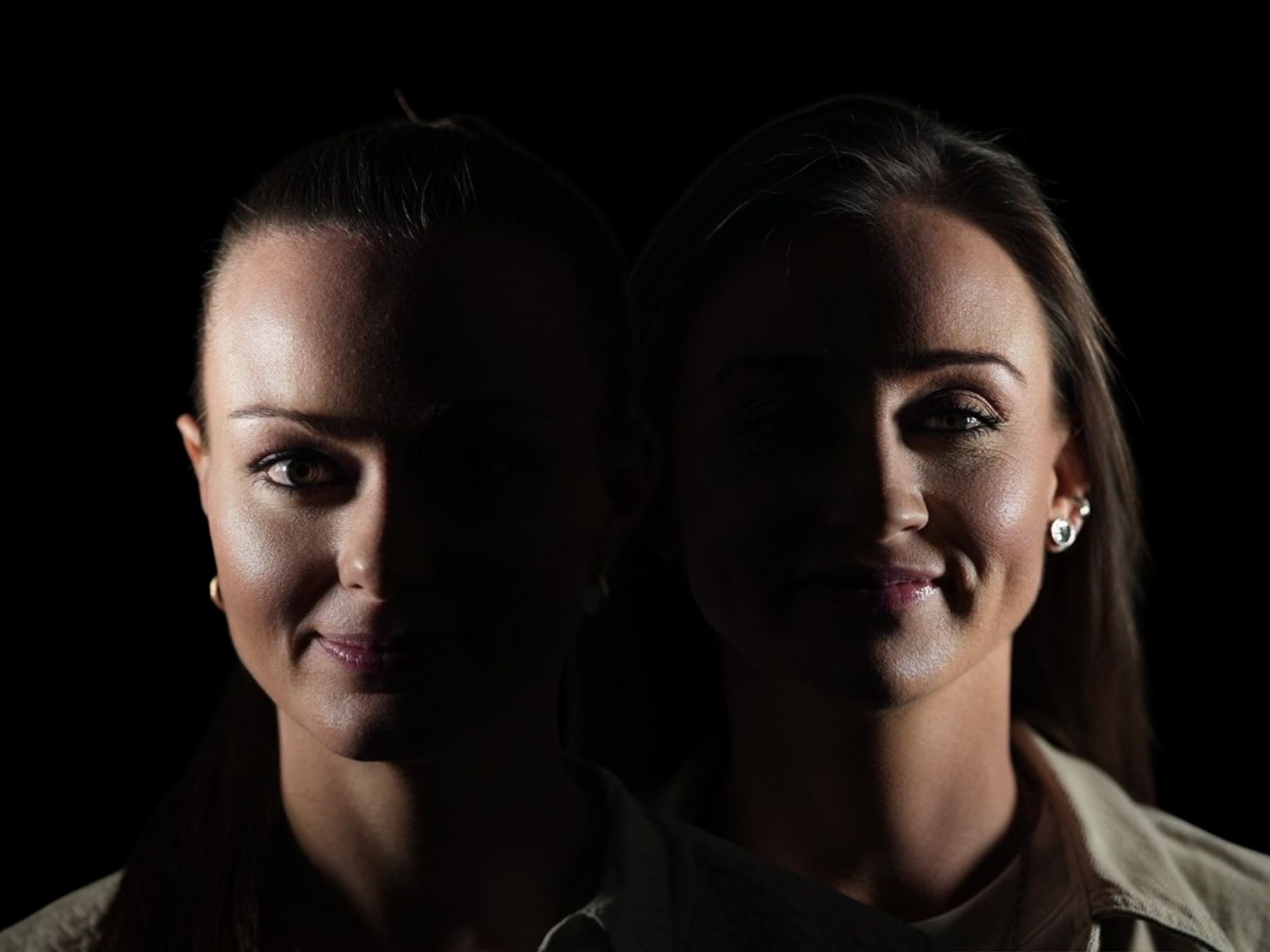 Porträts von zwei Frauen vor dunklem Hintergrund, die jeweils zur Hälfte von Licht und Schatten bedeckt sind, mit einem subtilen Lächeln und zurückhaltendem Make-up.
