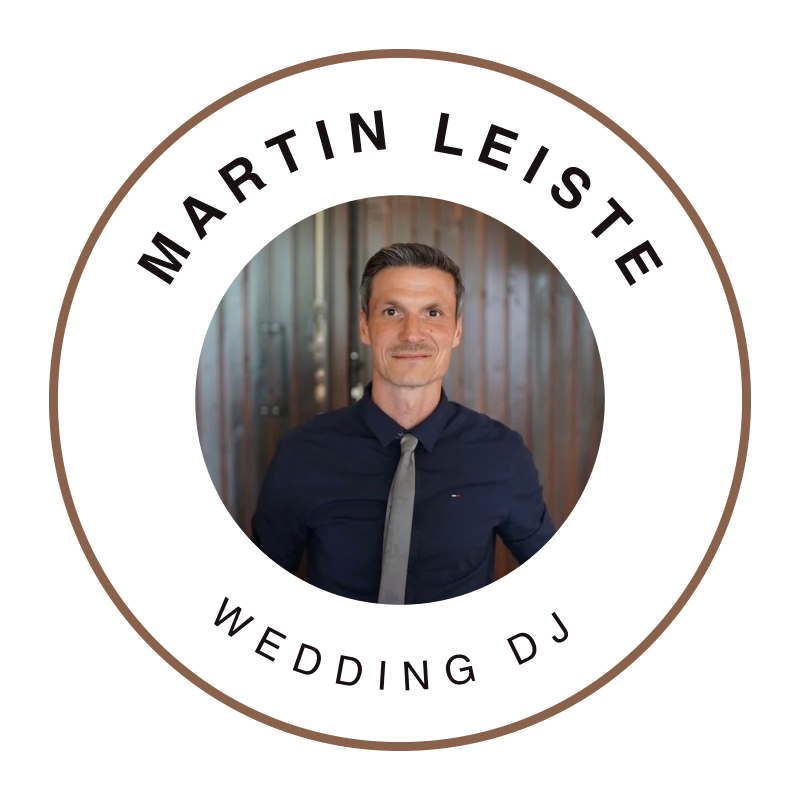 Porträtfoto eines Mannes mit dunklem Hemd und grauer Krawatte vor einem Holzhintergrund, umgeben von einem runden Rahmen mit dem Text Martin Leiste oben und Wedding DJ unten.