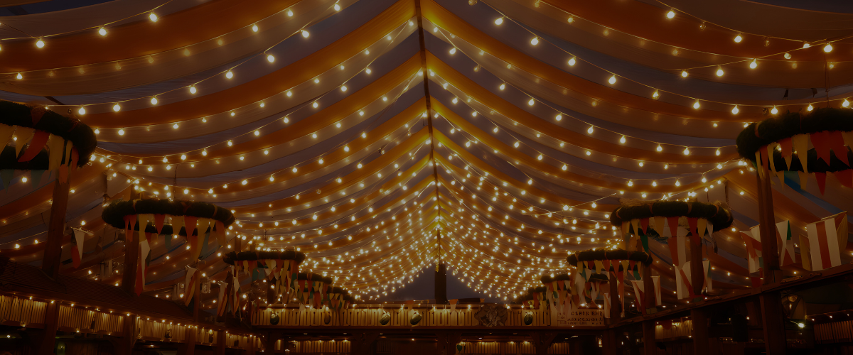 Musik beim Vereinsfest: Lichterketten im Festzelt bei einem Vereinsfest am Abend – warme Beleuchtung, festliche Stimmung und Musik in der Luft.