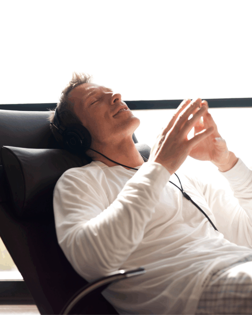 Musik bei Stress: Mann lehnt sich entspannt im Sessel zurück und hört Musik – Entspannung und Stressabbau durch Klänge.