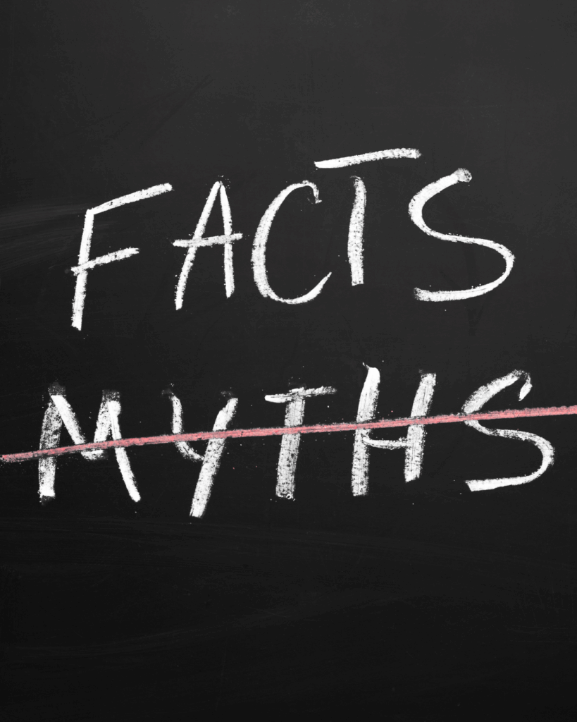 Mythen bzgl. Stimmgesundheit: Schwarze Tafel mit dem weißen Kreide-Schriftzug "FACTS" und dem durchgestrichenen Wort "MYTHS" in Weiß und Rot.