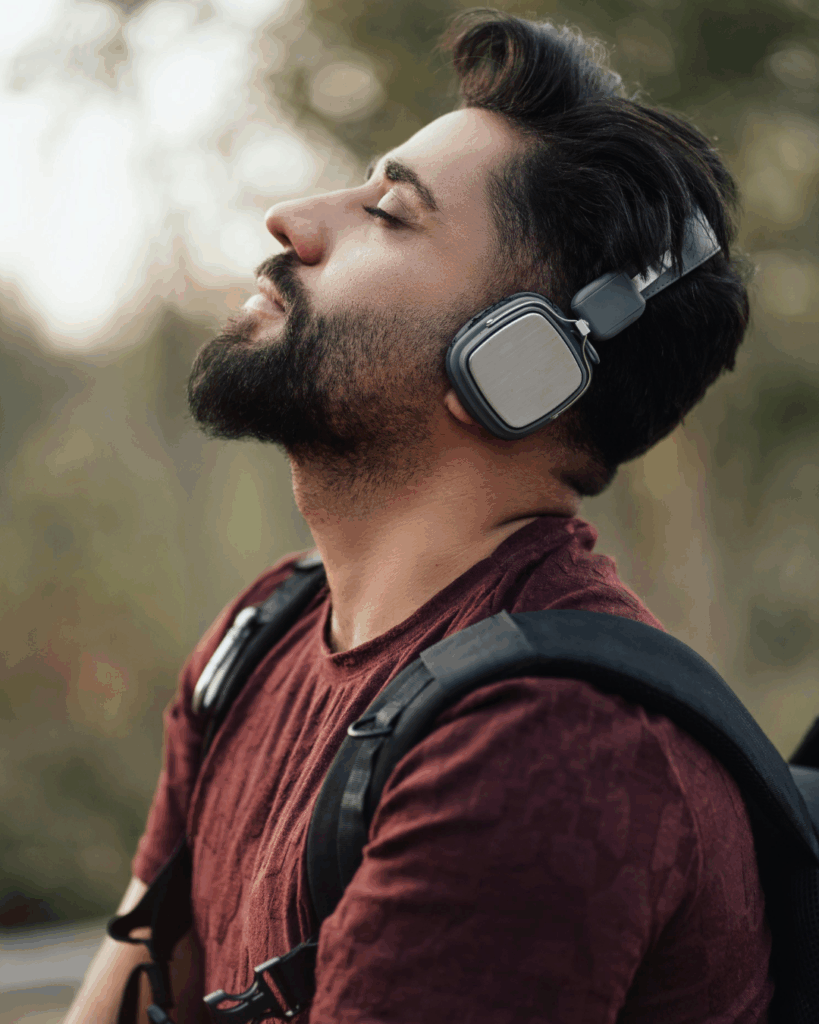 Musik und Stress: Mann mit Kopfhörern genießt im Freien Musik – Kombination aus Bewegung und Musik reduziert Stress effektiv.