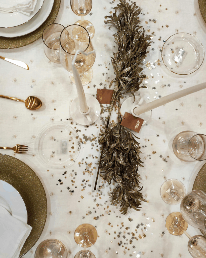 Festlich gedeckter Winterhochzeit-Tisch mit goldenen Akzenten, Kerzen und gläsernen Details.