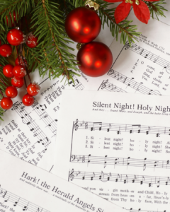 Alte Notenblätter mit Tannenzweig – frühe Wurzeln der Weihnachtsmusik im 18. Jahrhundert. Weihnachtliche Notenblätter mit Liedern, Tannenzweigen, roten Kugeln und Beeren als Dekoration.