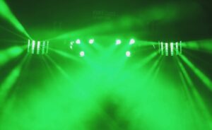 Grünes Bühnenlicht mit Nebel und gerichteten Strahlen in dunklem Raum